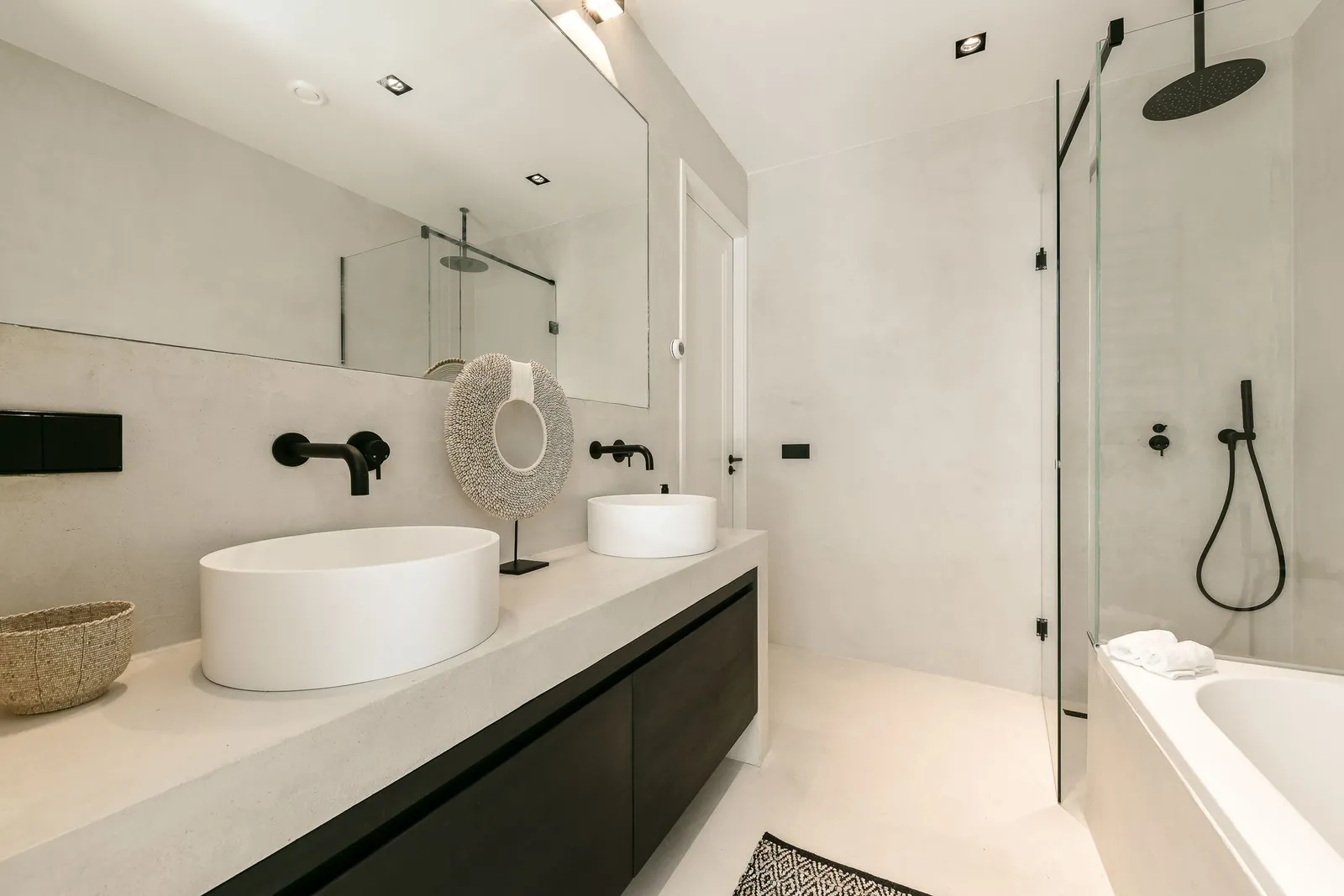 Modern bathroom with twin countertop basins and round mirror